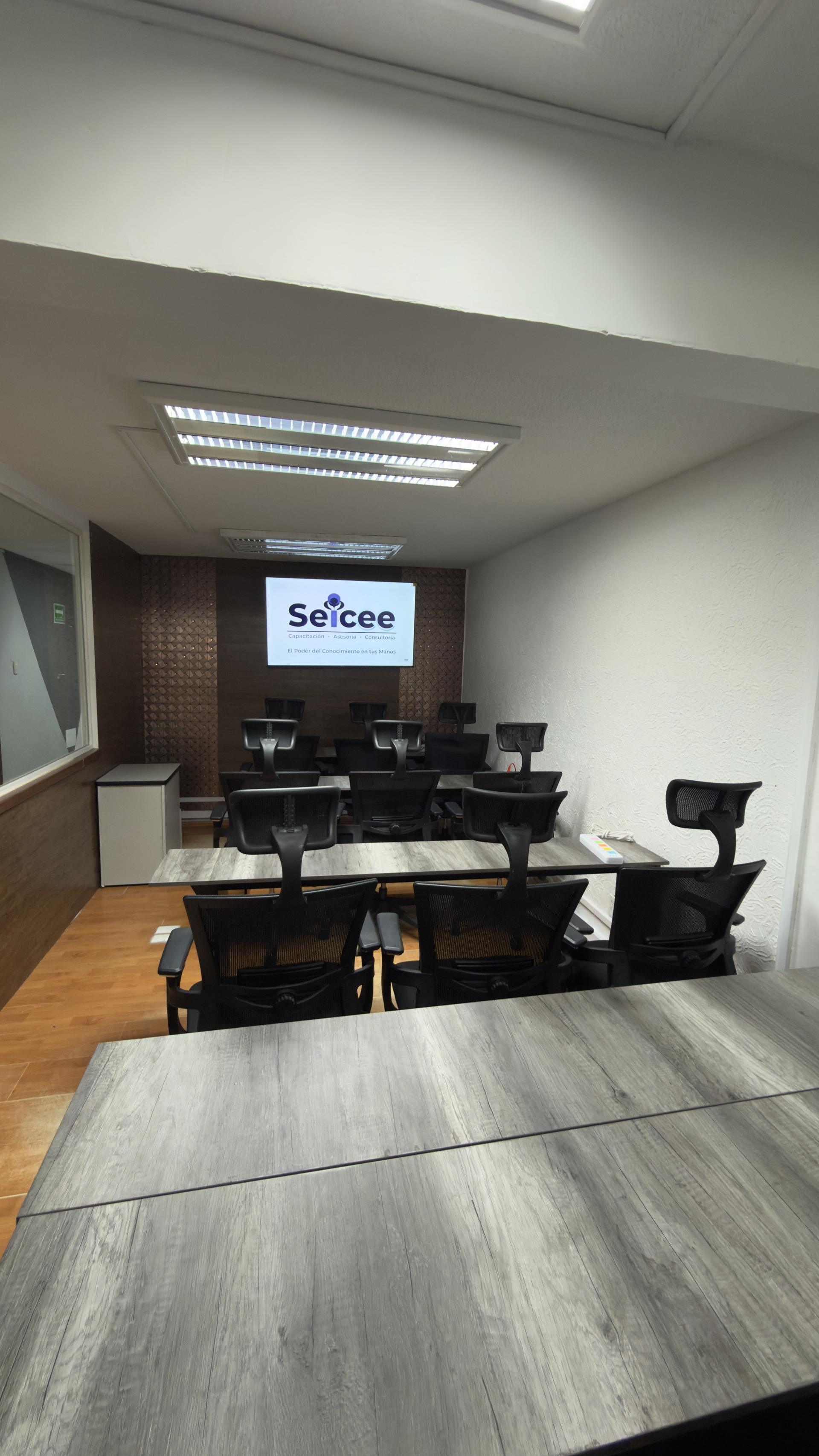 Sala de capacitación Seicee con pantalla, sillas ergonómicas y mesas listas